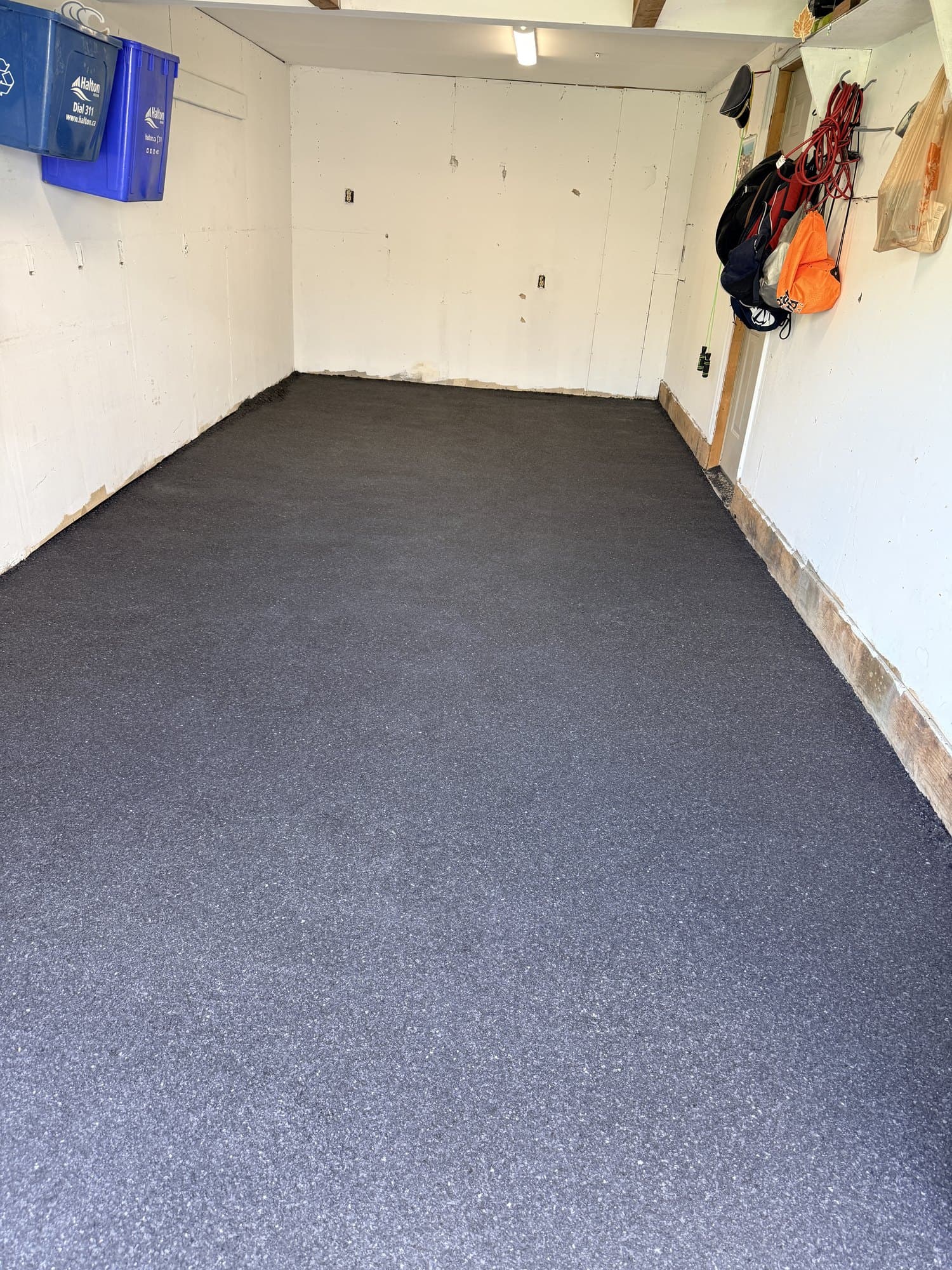 A finished charcoal flake epoxy garage floor seen from the doorway