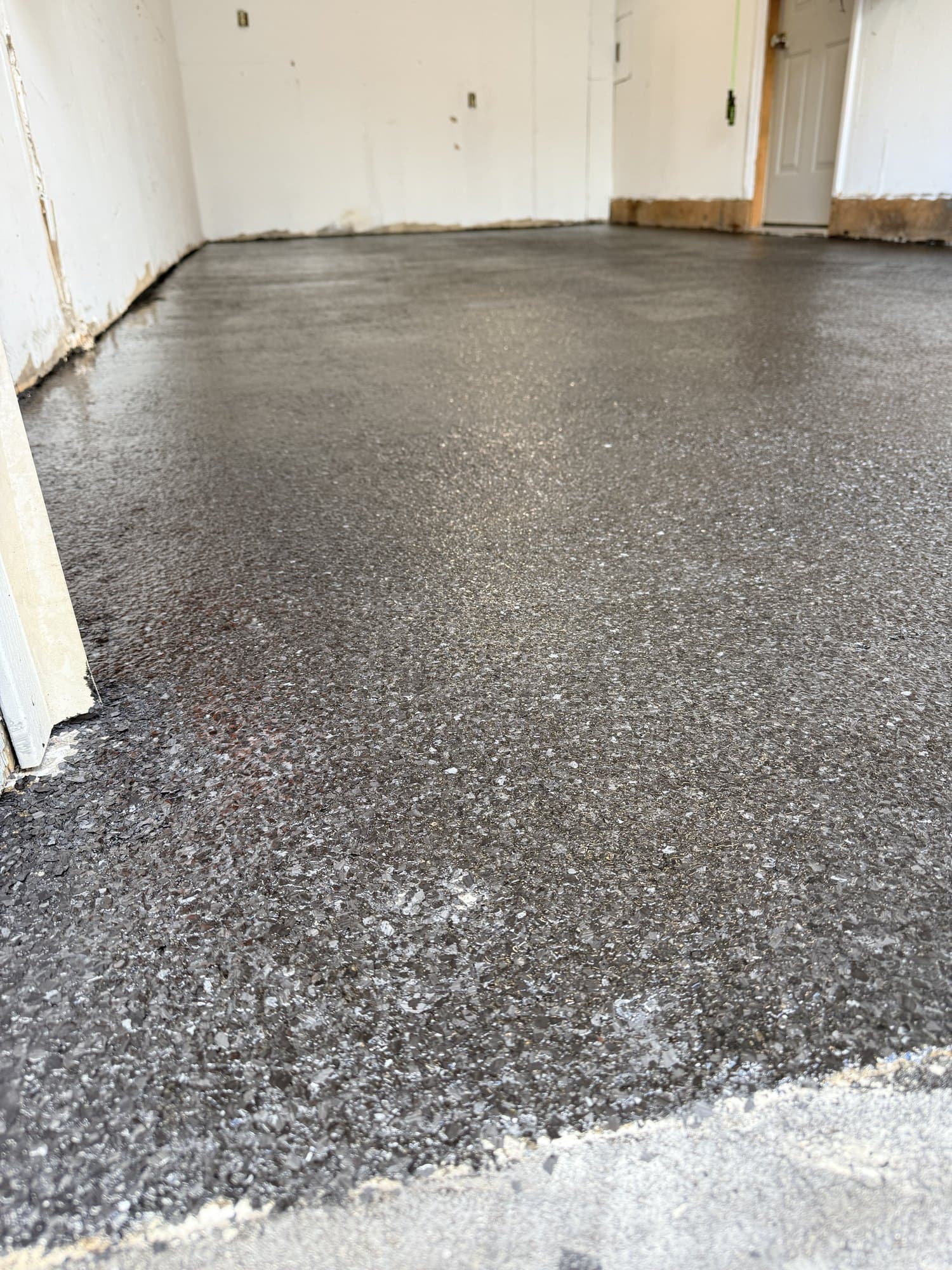 Close view of a finished flake epoxy floor meeting the garage threshold