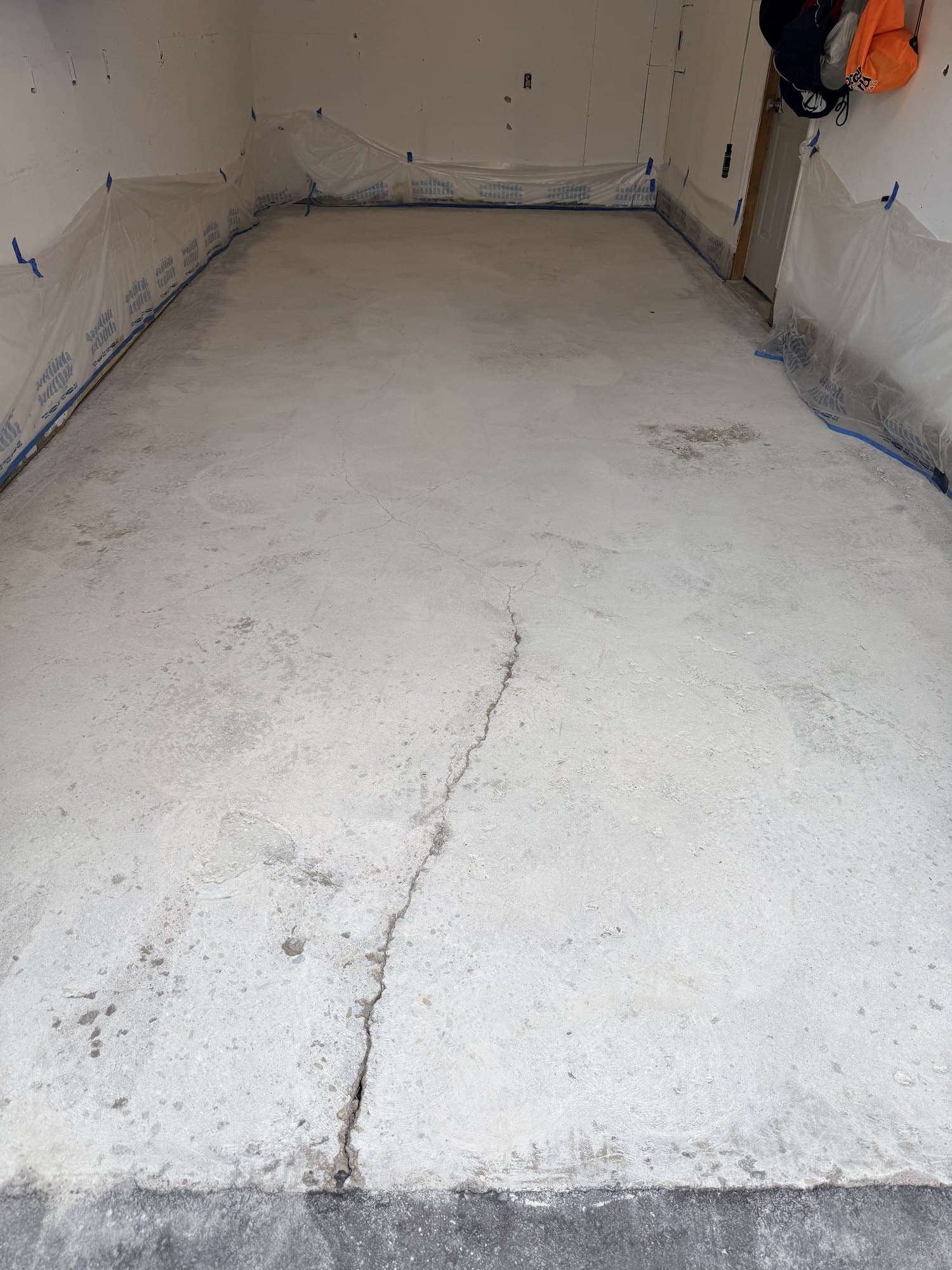 A residential garage slab before epoxy, with a crack running the full length of the floor