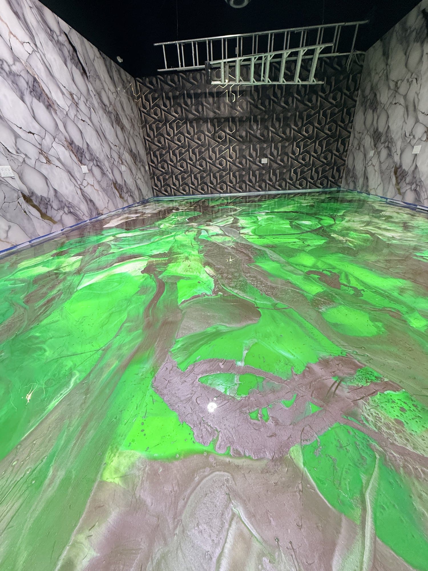 Close view of green and mauve metallic epoxy marbling on a commercial floor