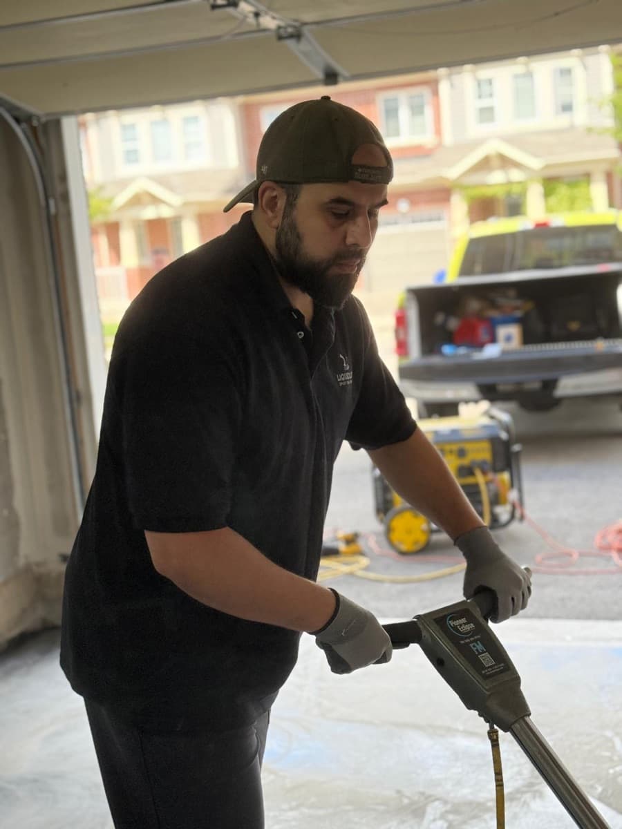 A LiquidLux installer grinding a concrete slab before coating
