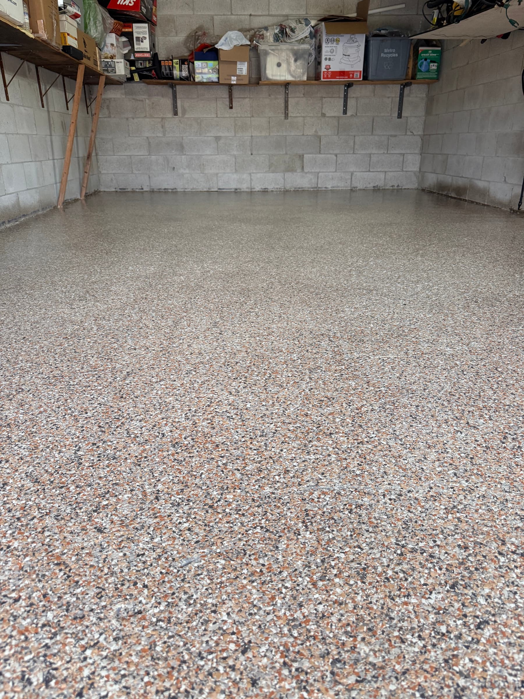 A finished LiquidLux beige and tan flake epoxy garage floor in a Milton home, wall to wall with a high-gloss sheen