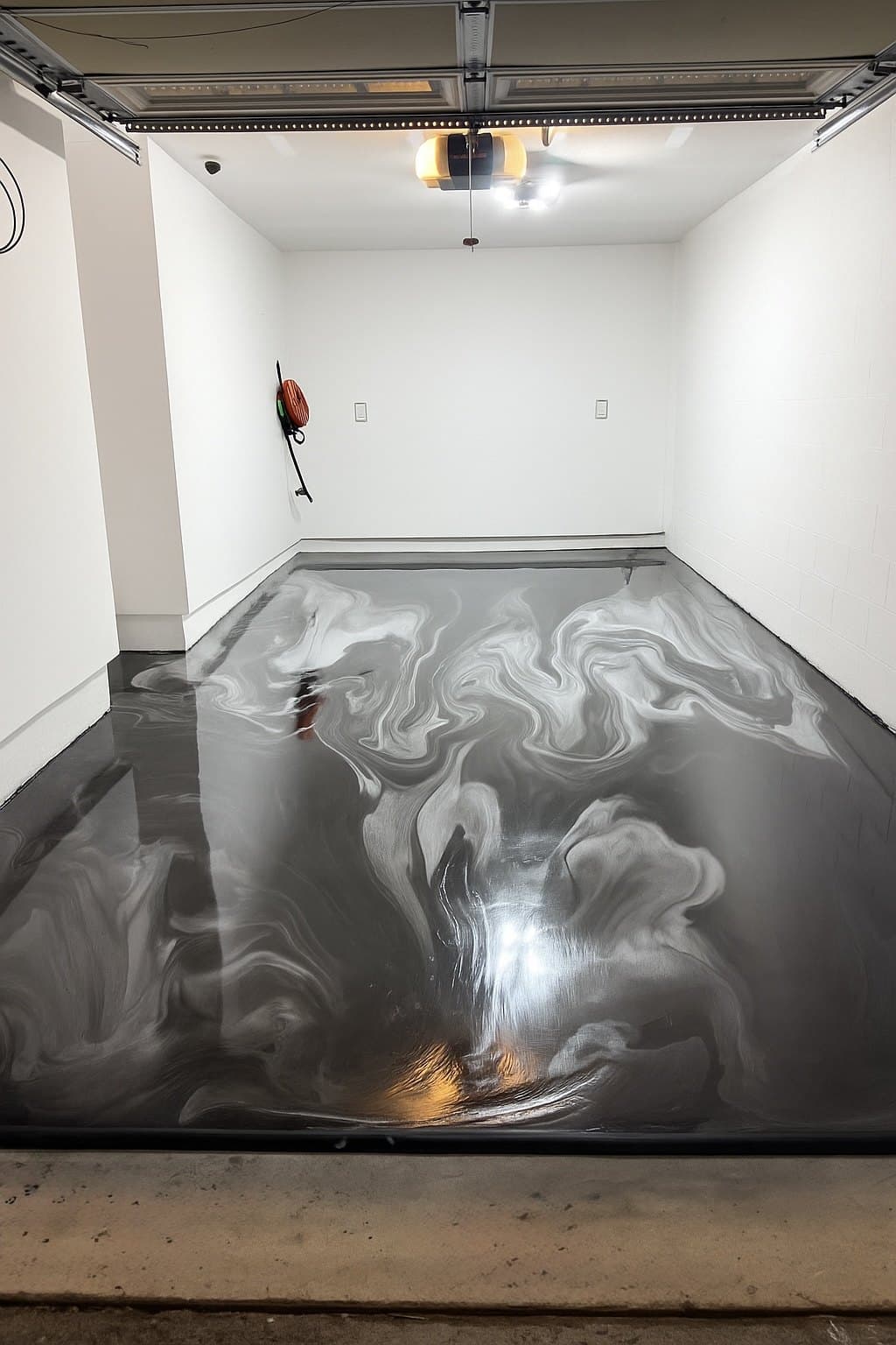 A finished silver and charcoal metallic epoxy floor with deep marbled swirls