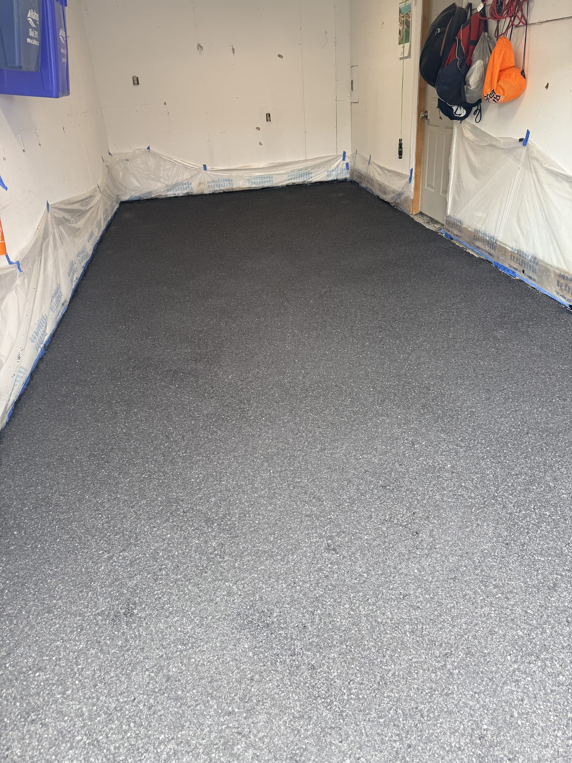 A charcoal flake epoxy floor finished in a below-grade room, sealed and seamless