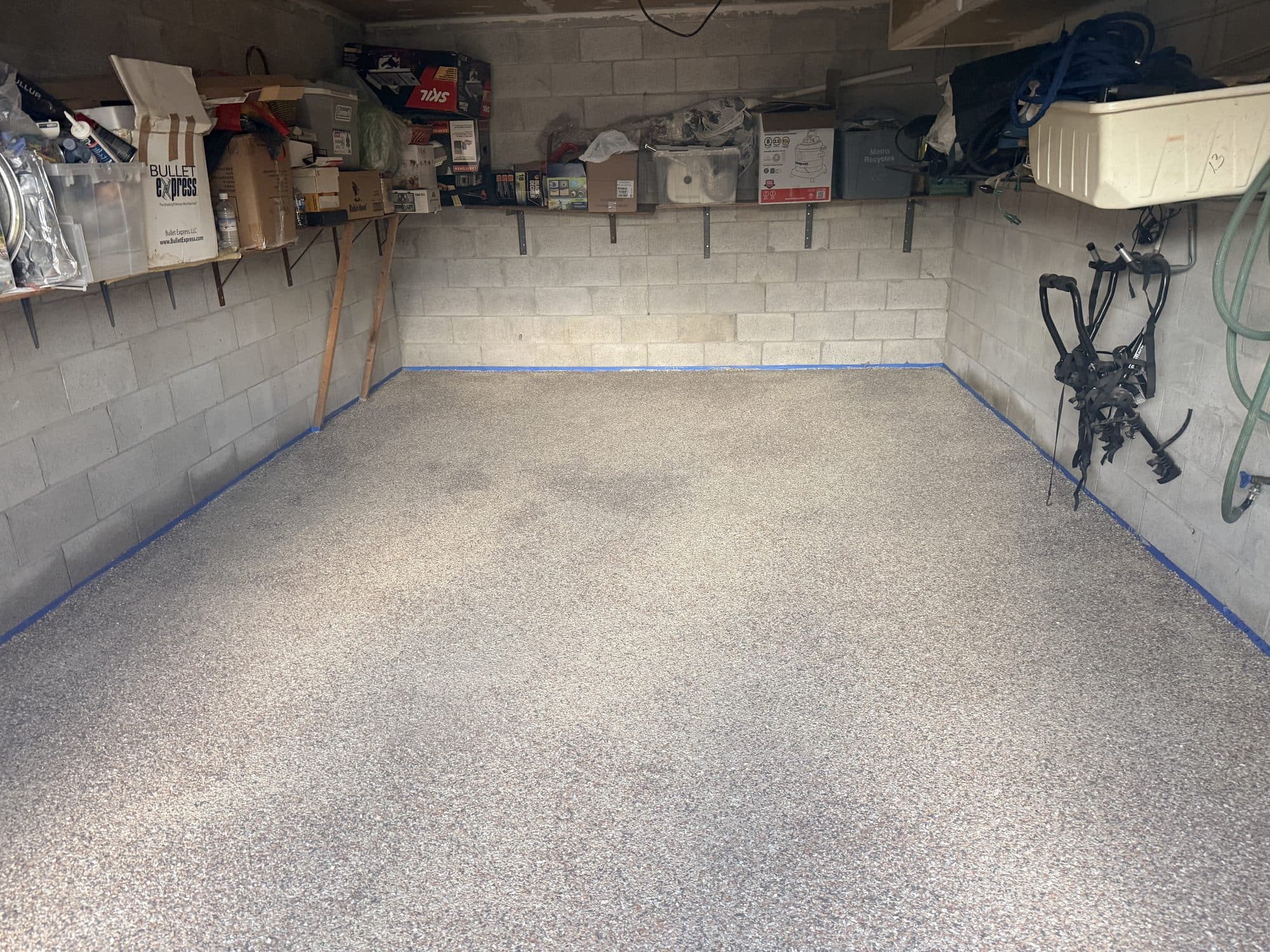 A finished LiquidLux flake epoxy garage floor photographed from the doorway, wall to wall